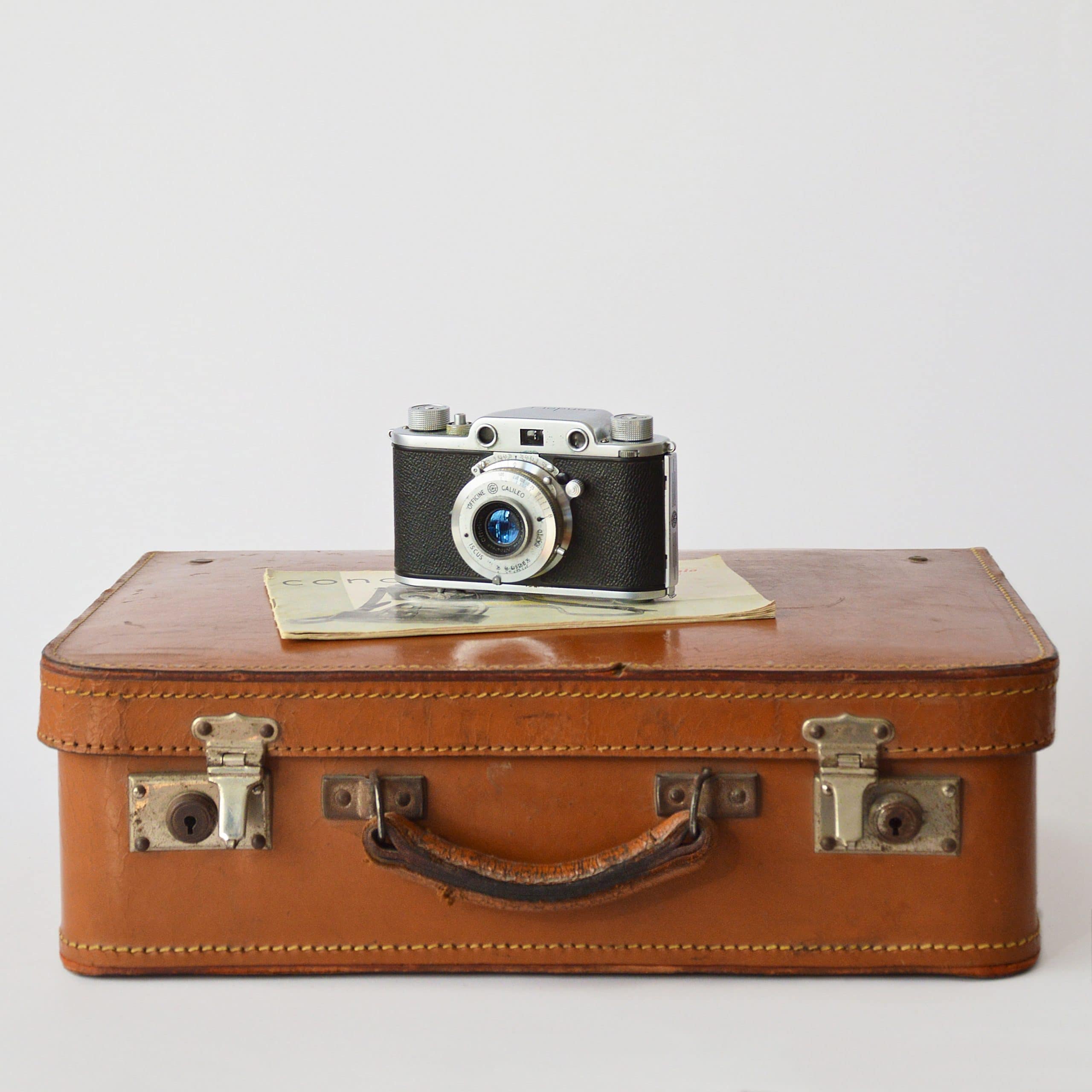 Valise en cuir avec appareil photo posé dessus