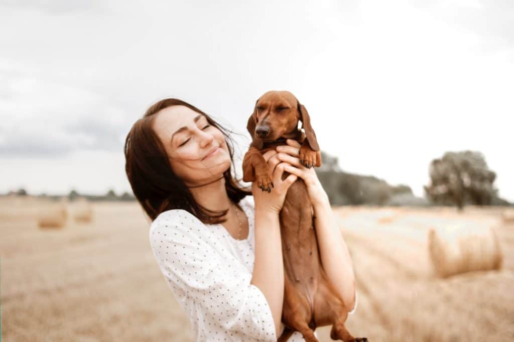 Femme qui prend un chien dans ses bras